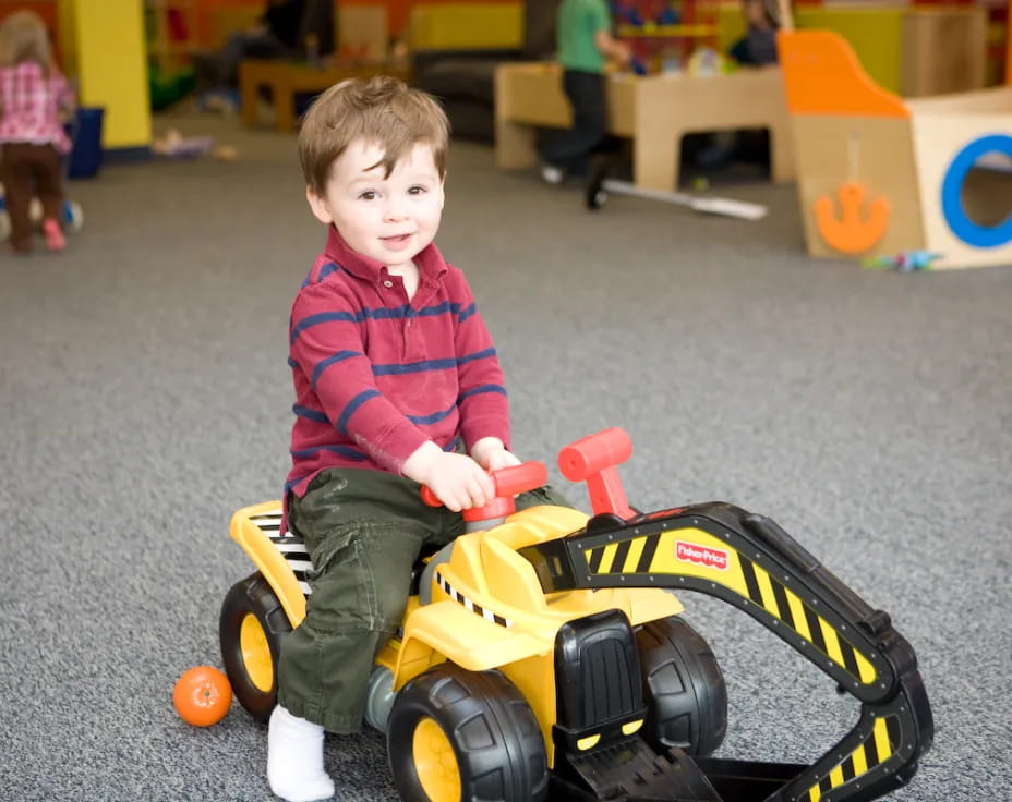 a boy sitting on a toy car