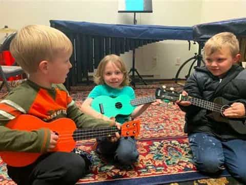 a group of kids playing guitar