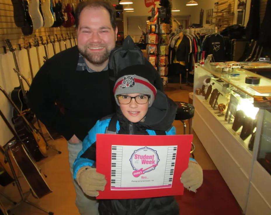a man and a boy holding a sign in a store