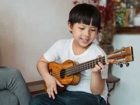 a young boy playing a guitar