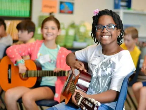 a group of kids playing guitars