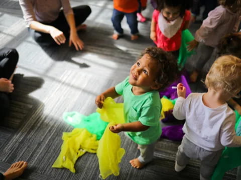 a group of children playing with a yellow and blue toy