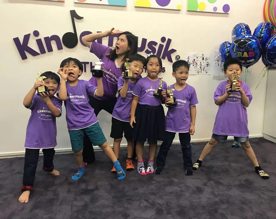 a group of kids posing for a picture with balloons