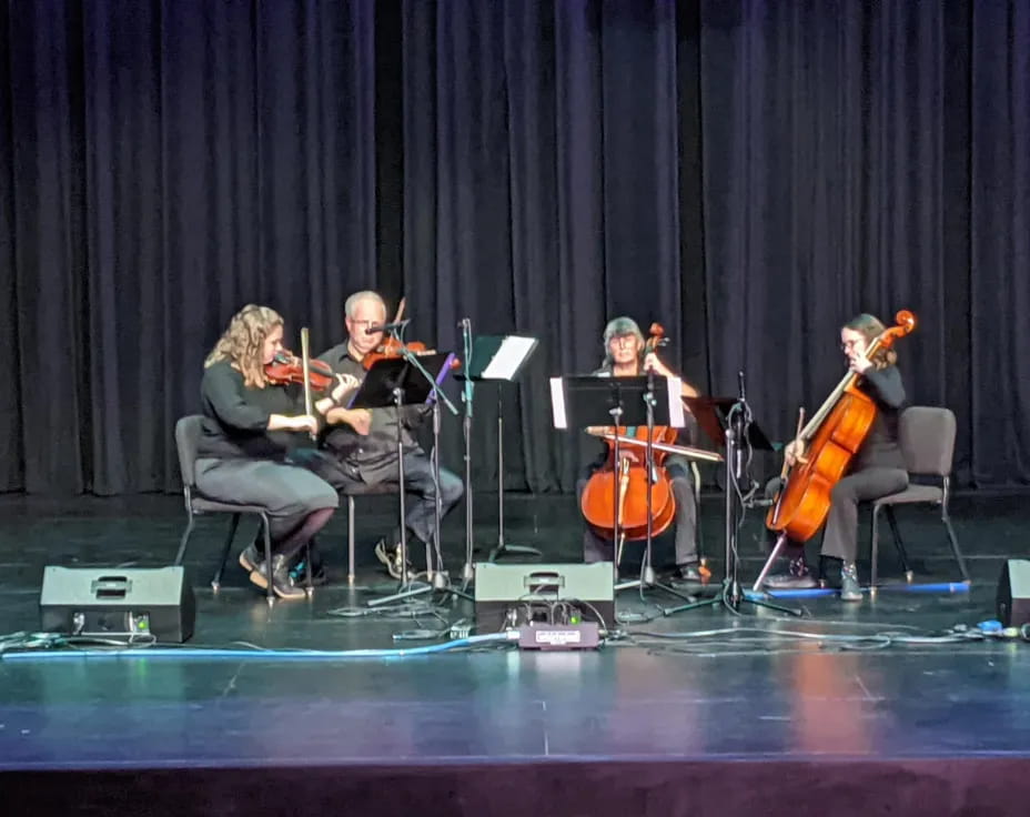 a group of people playing instruments on a stage