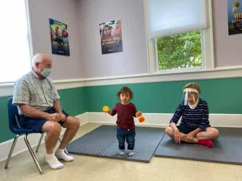 a person and a child sitting on a bench in a room