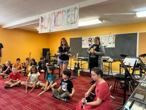 a group of people sitting on the floor playing instruments