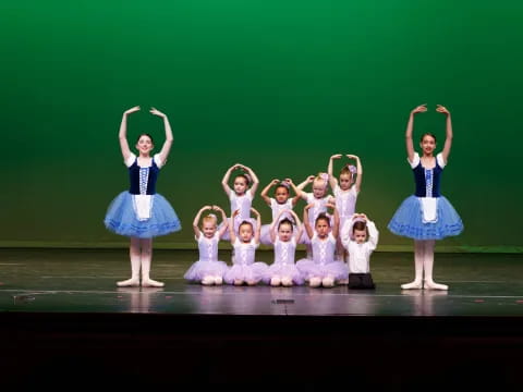 a group of girls in blue dresses on a stage