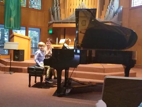 a couple of kids playing piano