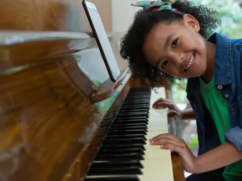 a young girl playing a piano
