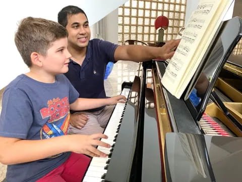 a person and a boy playing piano