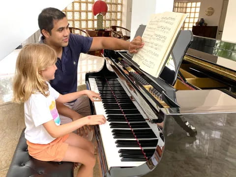 a person and a girl playing piano