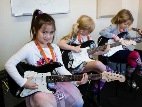 a group of girls playing guitars