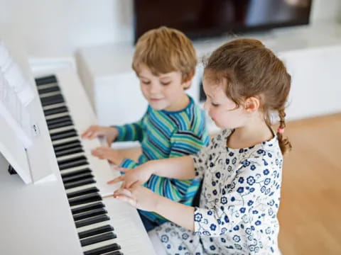 a couple of children playing piano