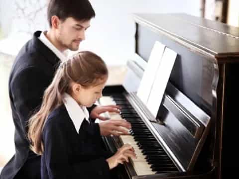 a man and a woman playing a piano