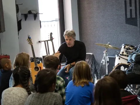 a person playing a guitar in front of a group of people