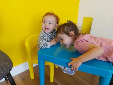 a couple of children sitting at a table