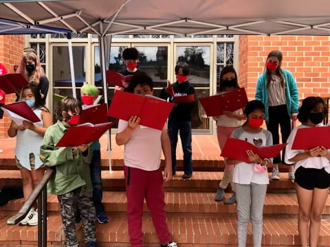 a group of people holding red and white signs