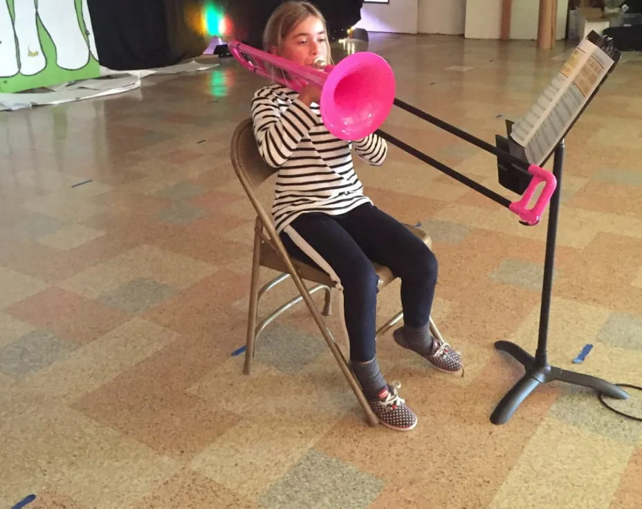 a person sitting in a chair holding a pink balloon