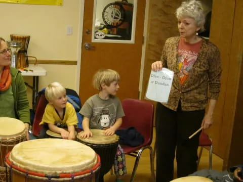 a person and a group of children playing drums