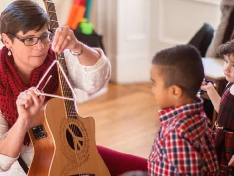 a person playing a guitar with children