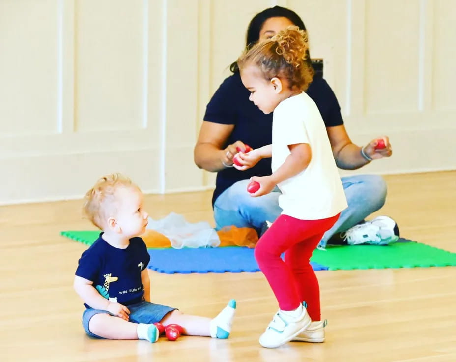 a person and two children playing on the floor