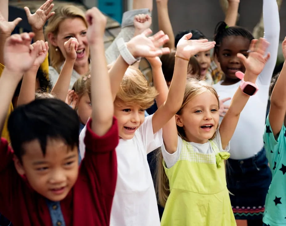 a group of children raising their hands