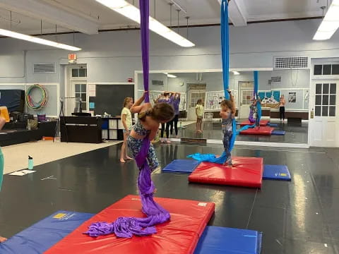 a group of children on mats in a gym