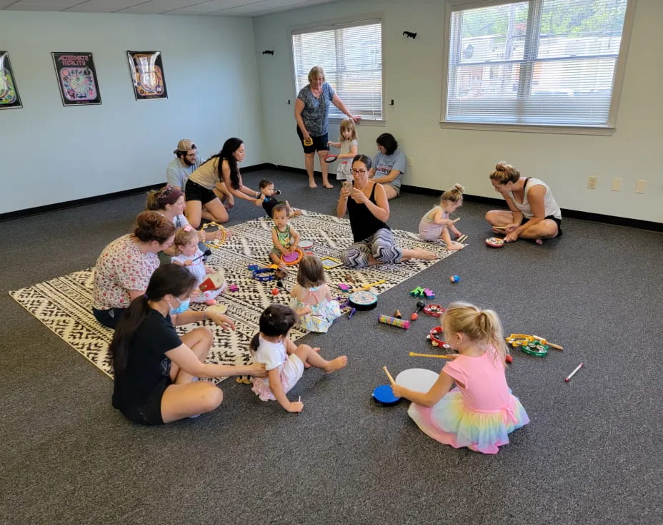 a group of people sitting on the floor playing with toys