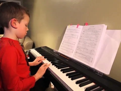 a boy playing a piano