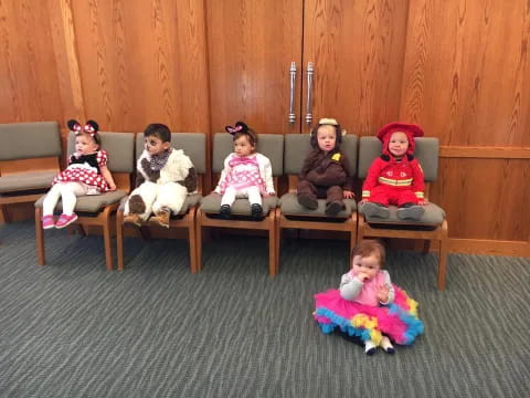 a group of children sitting on chairs