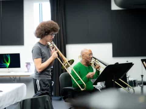 a woman playing a saxophone next to a man playing a saxophone