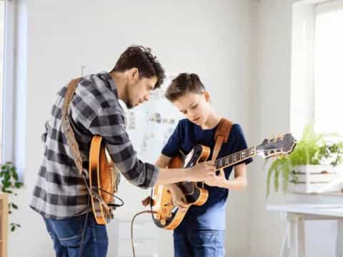 a man playing a guitar next to a man playing a guitar