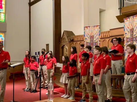 a group of people in red shirts standing in a church