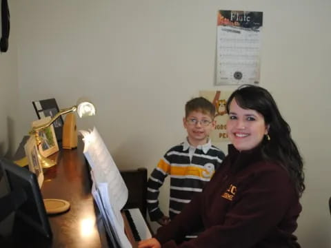 a person and a boy sitting at a desk