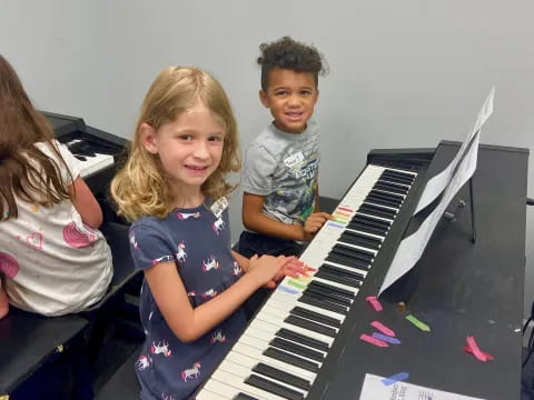 a group of children playing a piano