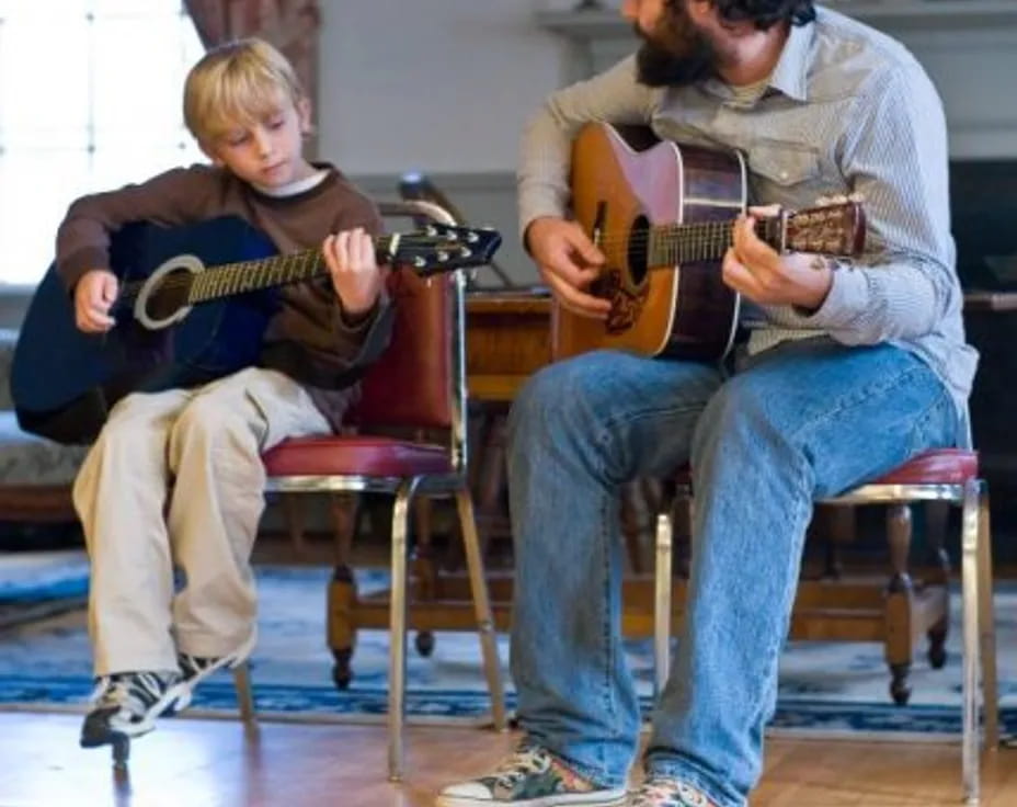 a person and a boy playing guitars
