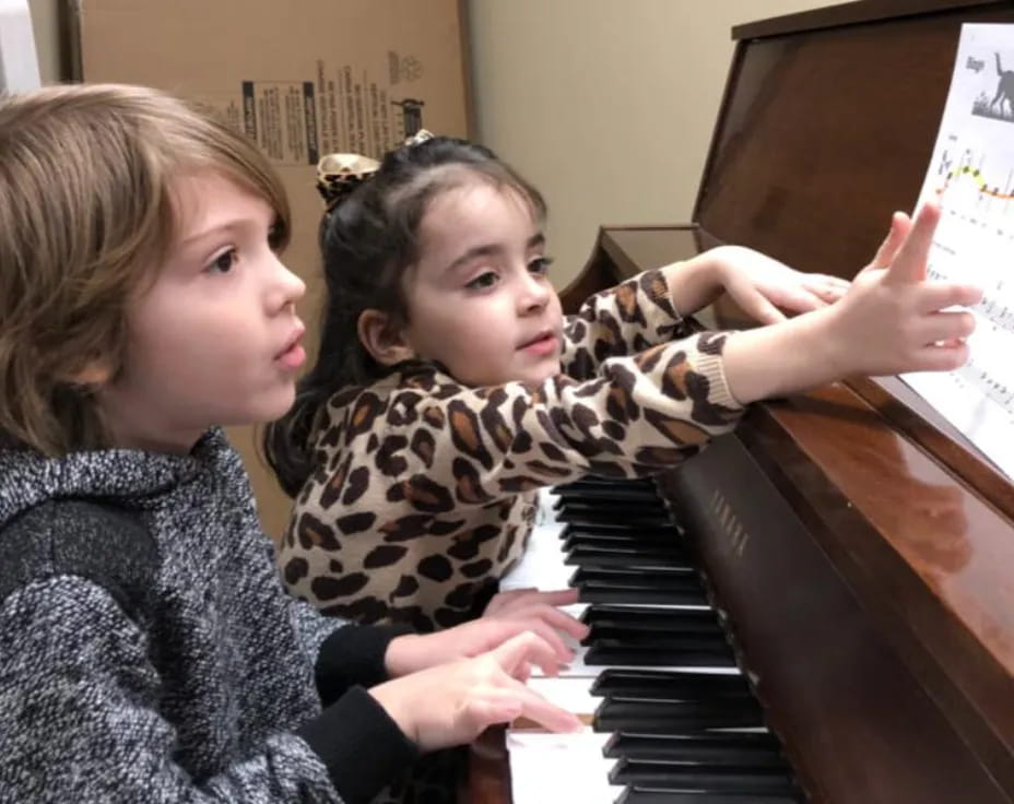 a couple of girls playing piano