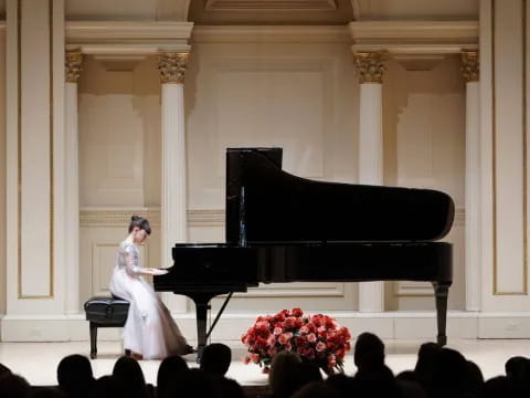 a person in a white dress on a stage with a piano