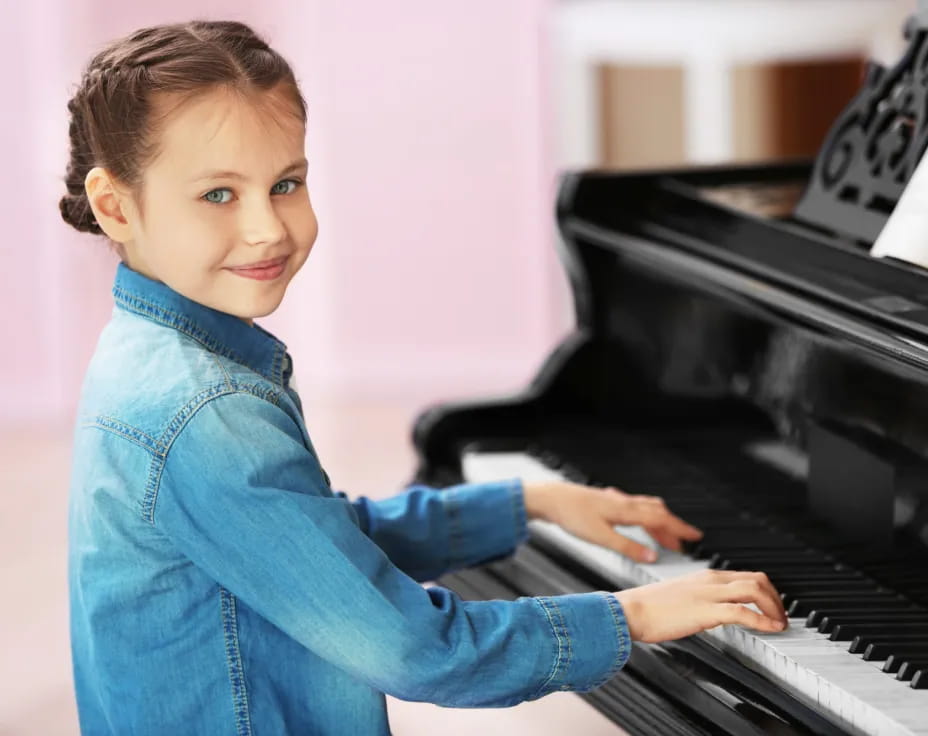 a young girl playing a piano