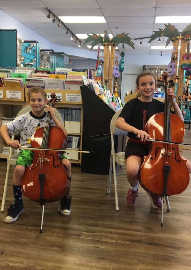 a couple of girls playing cellos