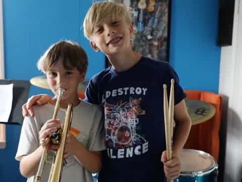 two boys holding musical instruments