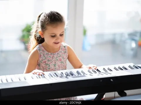 a little girl playing a piano