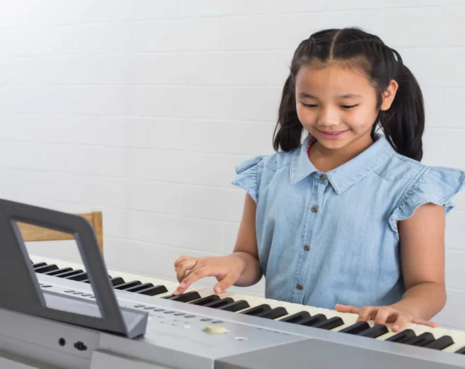 a young girl playing a piano