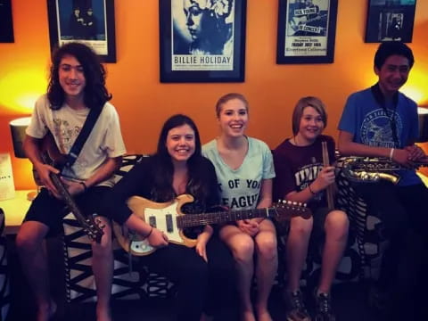 a group of people sitting on a couch with guitars