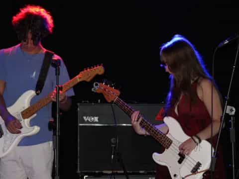 a man and woman playing guitars