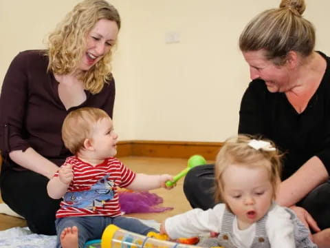 a group of people sitting on the floor with a baby in a basket