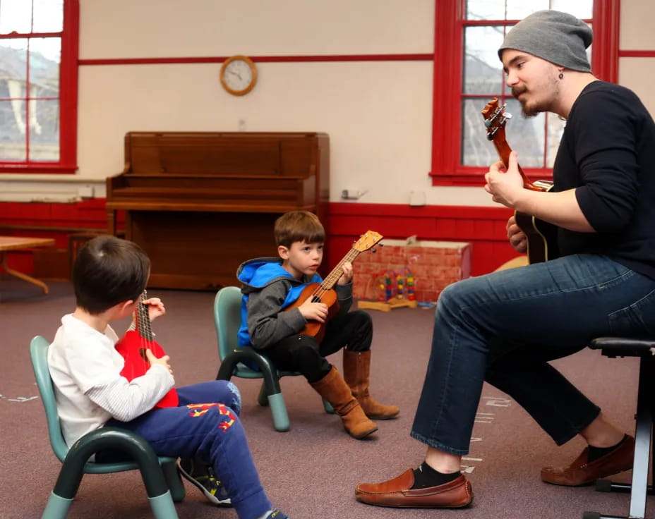 a person playing a violin to a couple of boys