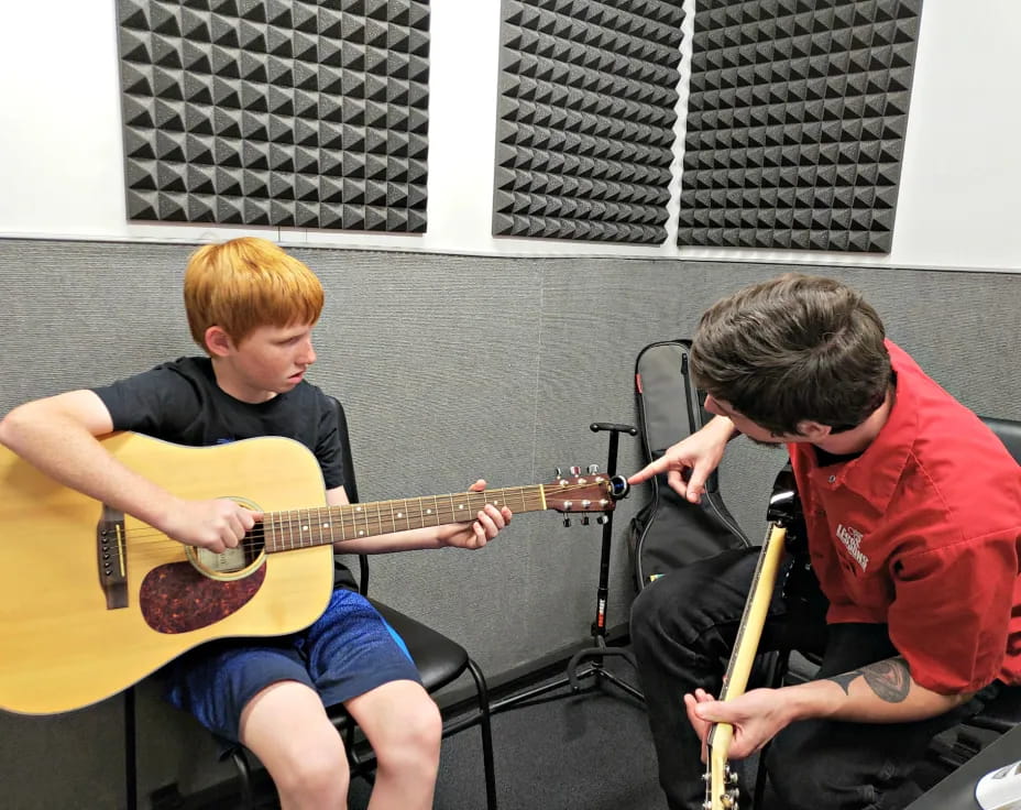 two boys playing guitars