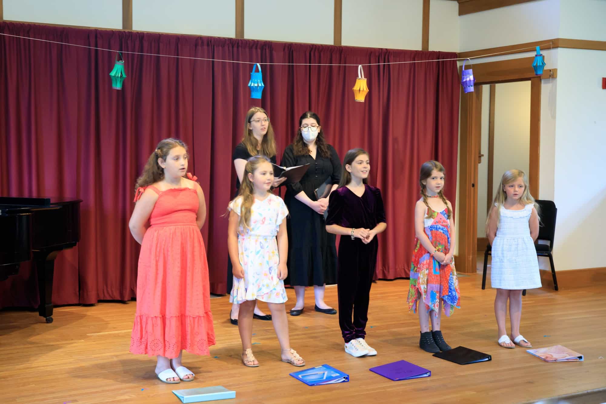 a group of people standing in front of a red curtain