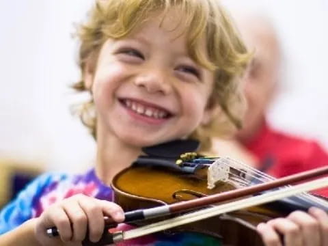 a young girl smiling and playing with a toy